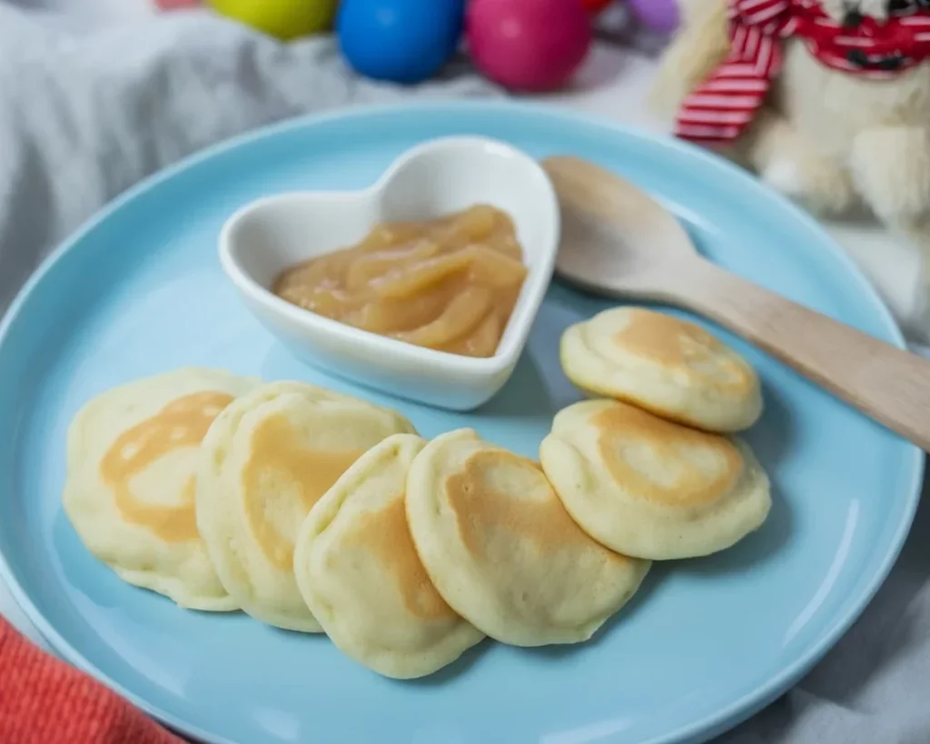 Vegane Pfannkuchen mit Apfelmus, serviert mit frischen Toppings und Ahornsirup.